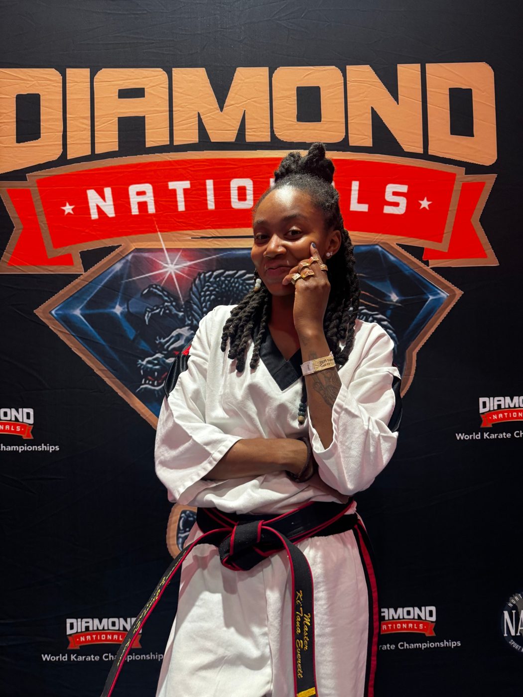 Ki'Tana Everett wearing her Diamond Nationals rings in front of the Diamond Nationals backdrop